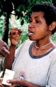 Woman using betel flower to scoop lime, PNG.
